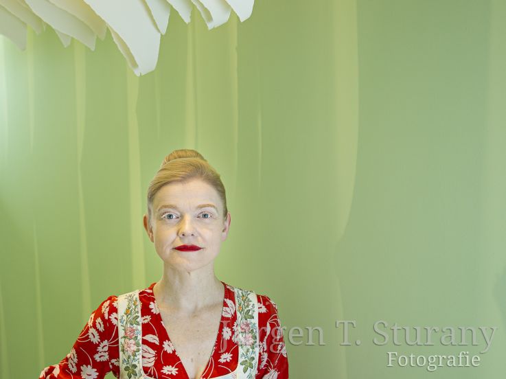 Sasa Hanten-Schmidt unter einem Papierobjekt von Angela Glajcar – Köln 2019